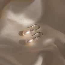 Brincos de pérolas e diamantes pendurados